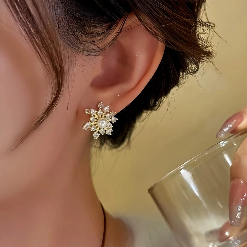 Model showcasing the dangle and style of the 14K Gold-Plated Zircon Diamond Rotating Snowflake Earrings