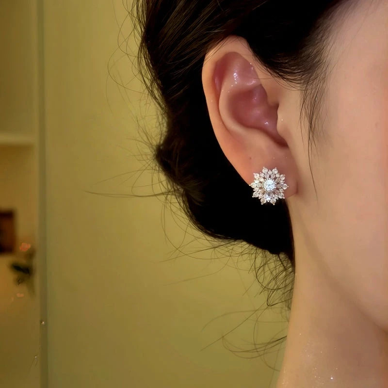 Model showcasing the dangle and style of the 14K Gold-Plated Zircon Diamond Snowflake Stud Earrings