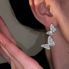 Model showcasing the dangle and style of the 14K Gold-Plated Zircon Double-Butterfly Earrings