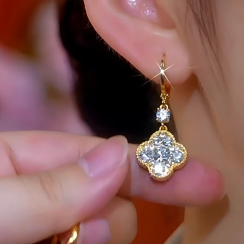 Model showcasing the dangle and style of the 14K Gold-Plated Zircon Double-Sided Four-Leaf Clover Earrings