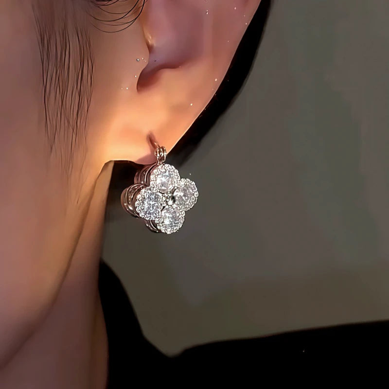 Model showcasing the dangle and style of the 14K Gold-Plated Zircon Double-Sided Lucky Flower Earrings