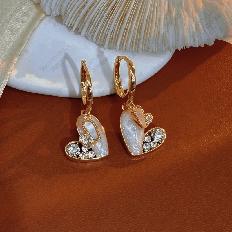 Model showcasing the dangle and style of the 14K Gold-Plated Zircon Double Heart Earrings