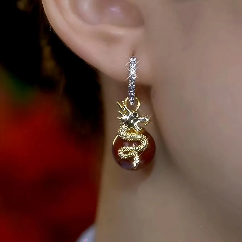 Model showcasing the dangle and style of the 14K Gold-Plated Zircon Dragon Pearl Earrings