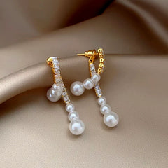 Model showcasing the dangle and style of the 14K Gold-Plated Zircon Face-Slimming Pearl Earrings