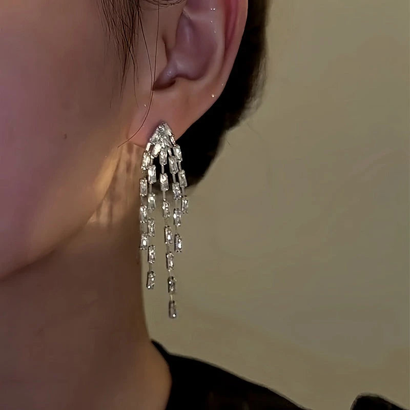 Model showcasing the dangle and style of the 14K Gold-Plated Zircon Firework Tassel Earrings