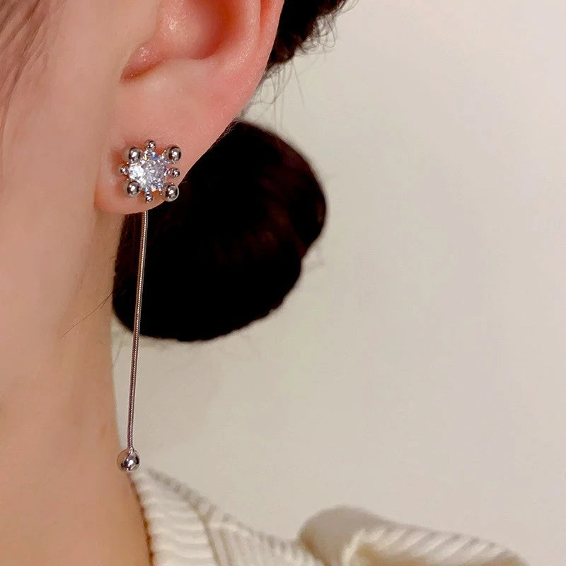 Model showcasing the dangle and style of the 14K Gold-Plated Zircon Fireworks Tassel Two-Wear Earrings