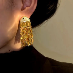 Close-up detail of the sparkling zircons and plating on the gold tassel earrings