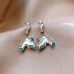 Angled view of the 14K Gold-Plated Zircon Fishtail Tassel Earrings