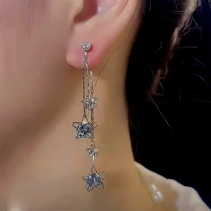 Model showcasing the dangle and style of the 14K Gold-Plated Zircon Five-Pointed Star Tassel Earrings