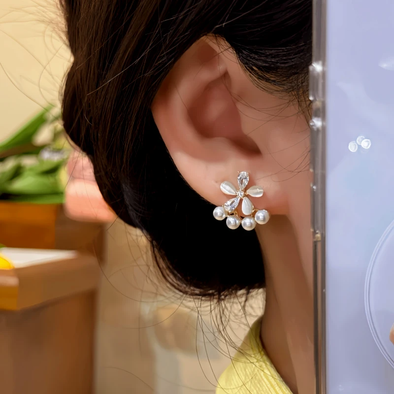 Model showcasing the dangle and style of the 14K Gold-Plated Zircon Flower Bead Jacket Earrings