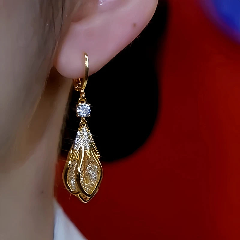 Model showcasing the dangle and style of the 14K Gold-Plated Zircon Flower Bud Gold Wire Mesh Earrings