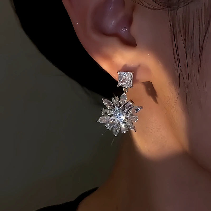 Model showcasing the dangle and style of the 14K Gold-Plated Zircon Flower Earrings
