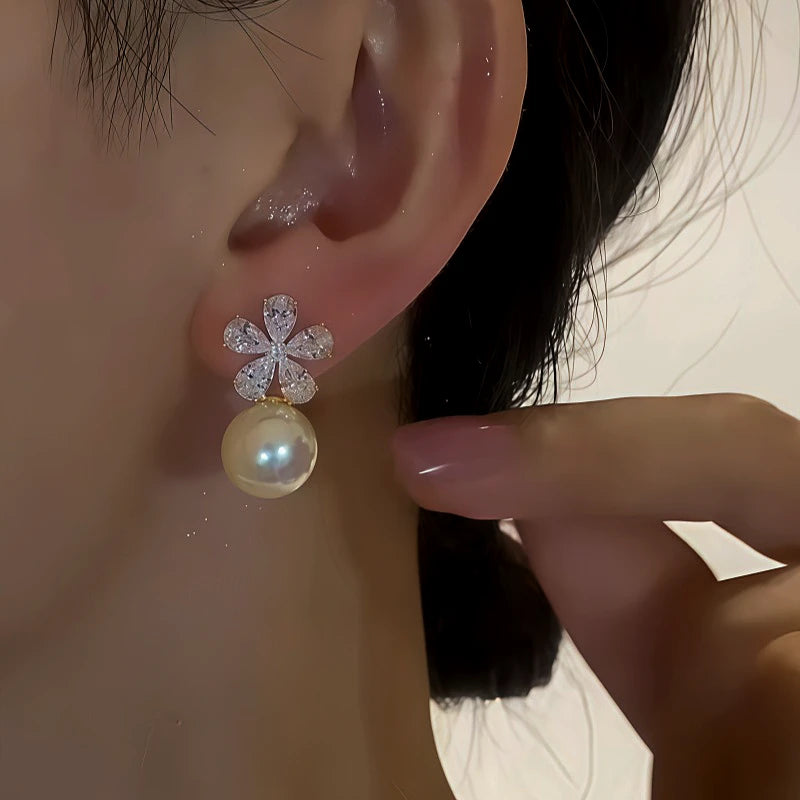 Model showcasing the dangle and style of the 14K Gold-Plated Zircon Flower Pearl Earrings