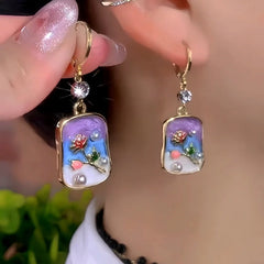 Model showcasing the dangle and style of the 14K Gold-Plated Zircon Flower Pearl Earrings