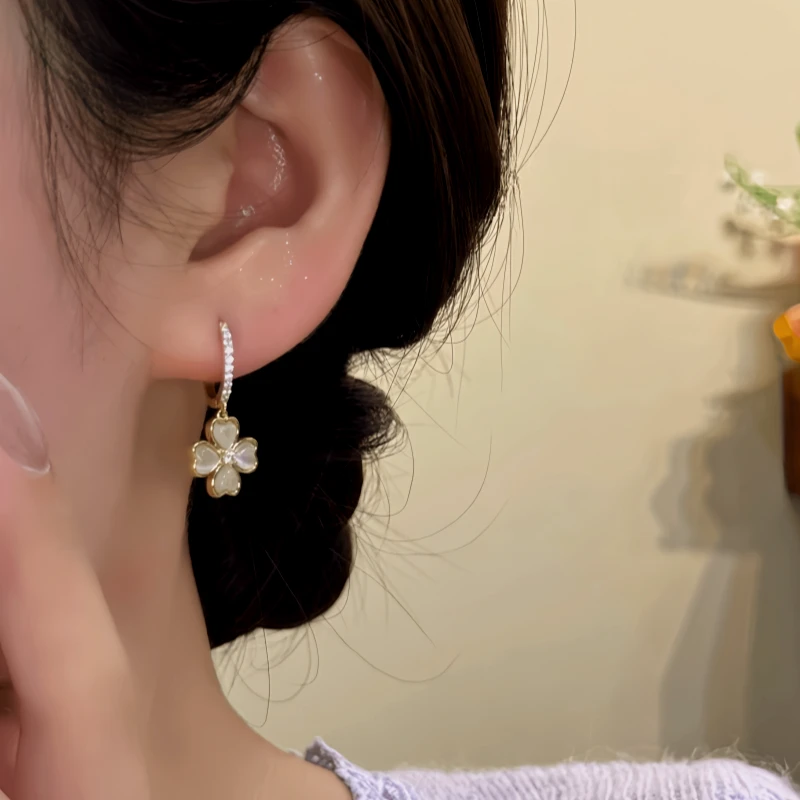 Model showcasing the dangle and style of the 14K Gold-Plated Zircon Four-Leaf Cat's Eye Stone Earrings