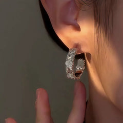 Model showcasing the dangle and style of the 14K Gold-Plated Zircon Four-Leaf Clover C-Shaped Earrings