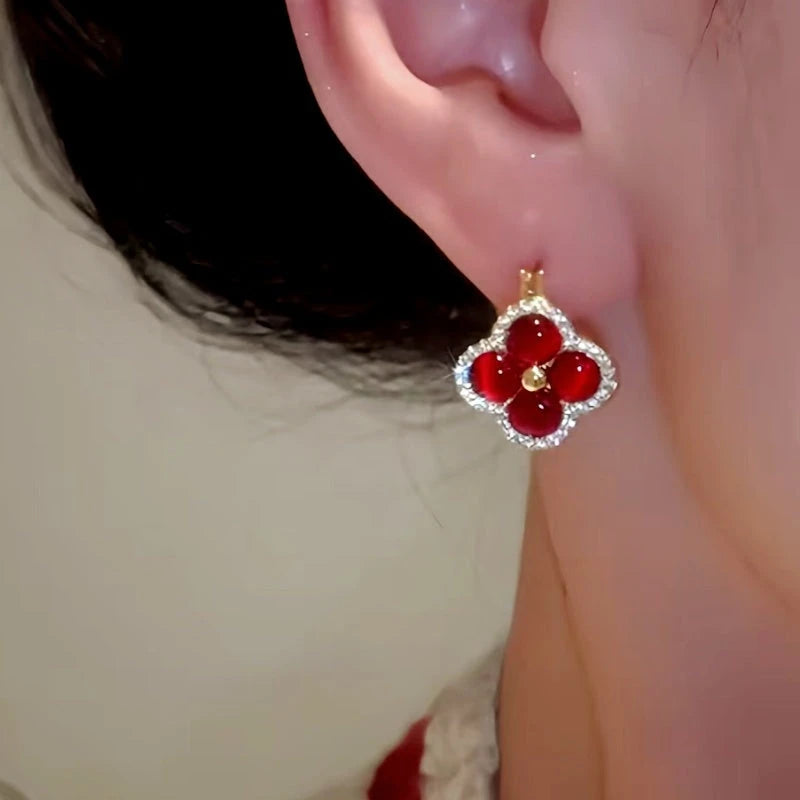 Model showcasing the dangle and style of the 14K Gold-Plated Zircon Four-Leaf Flower Earrings