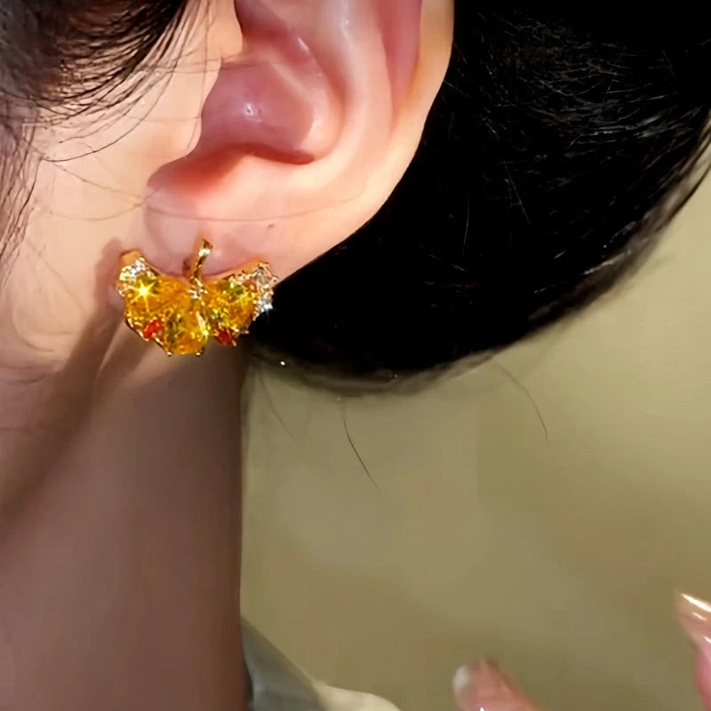 Model showcasing the dangle and style of the 14K Gold-Plated Zircon Gingko Leaf Earrings