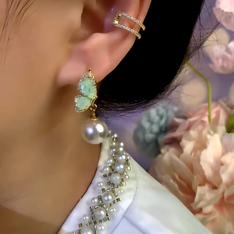 Model showcasing the dangle and style of the 14K Gold-Plated Zircon Green Crystal Butterfly Bead Earrings