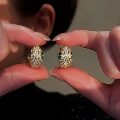 Angled view of the 14K Gold-Plated Zircon Green Eye Snake Hoop Earrings