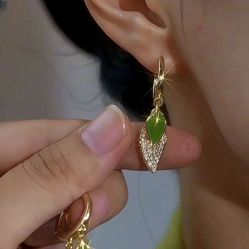 Model showcasing the dangle and style of the 14K Gold-Plated Zircon Green Leaf Earrings