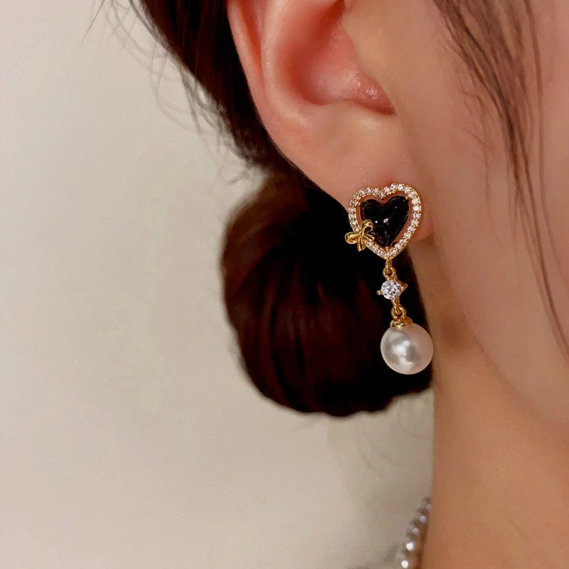 Model showcasing the dangle and style of the 14K Gold-Plated Zircon Heart-Shaped Pearl Earrings