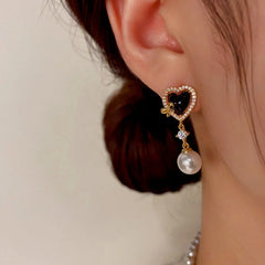 Model showcasing the dangle and style of the 14K Gold-Plated Zircon Heart-Shaped Pearl Earrings