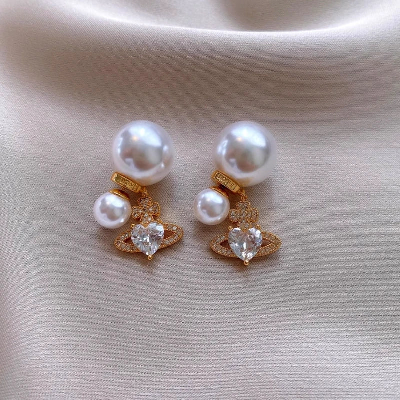 Angled view of the 14K Gold-Plated Zircon Heart Bead Tassel Jacket Earrings