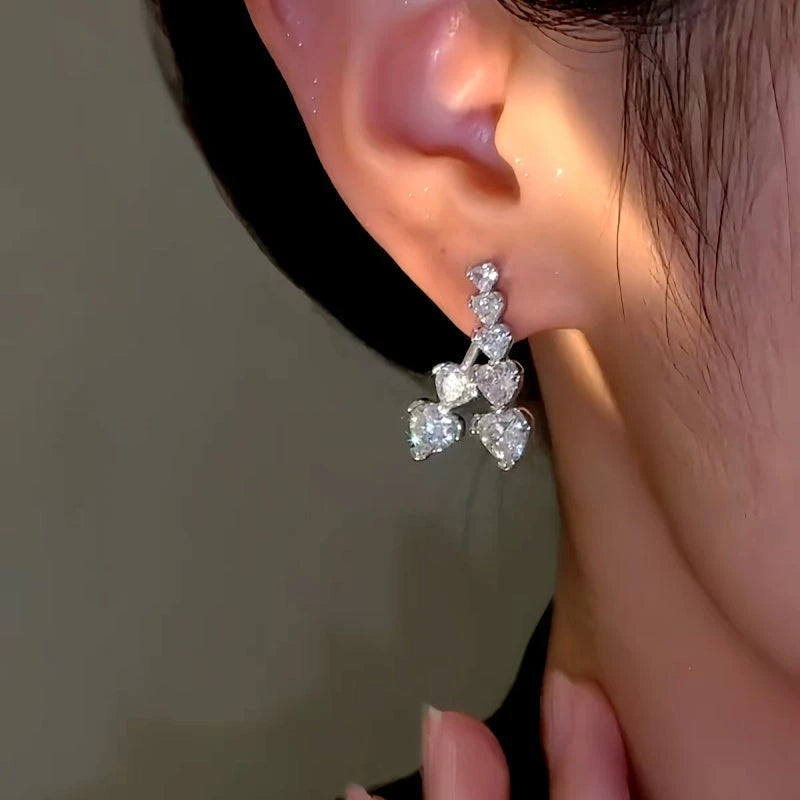 Model showcasing the dangle and style of the 14K Gold-Plated Zircon Heart Earrings