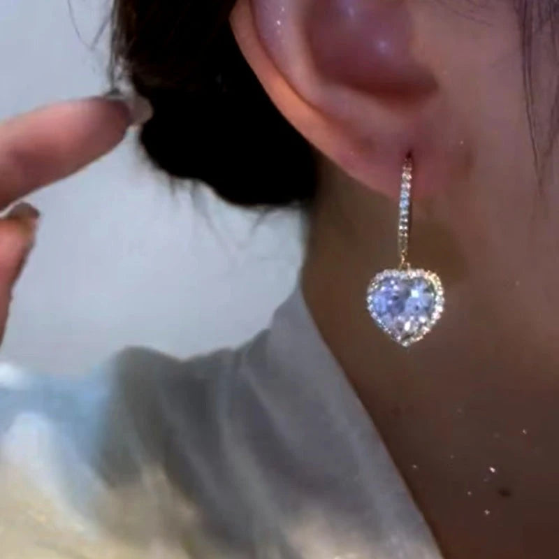 Model showcasing the dangle and style of the 14K Gold-Plated Zircon Heart Earrings