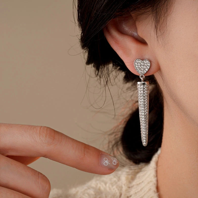 Model showcasing the dangle and style of the 14K Gold-Plated Zircon Heart Tassel Earrings