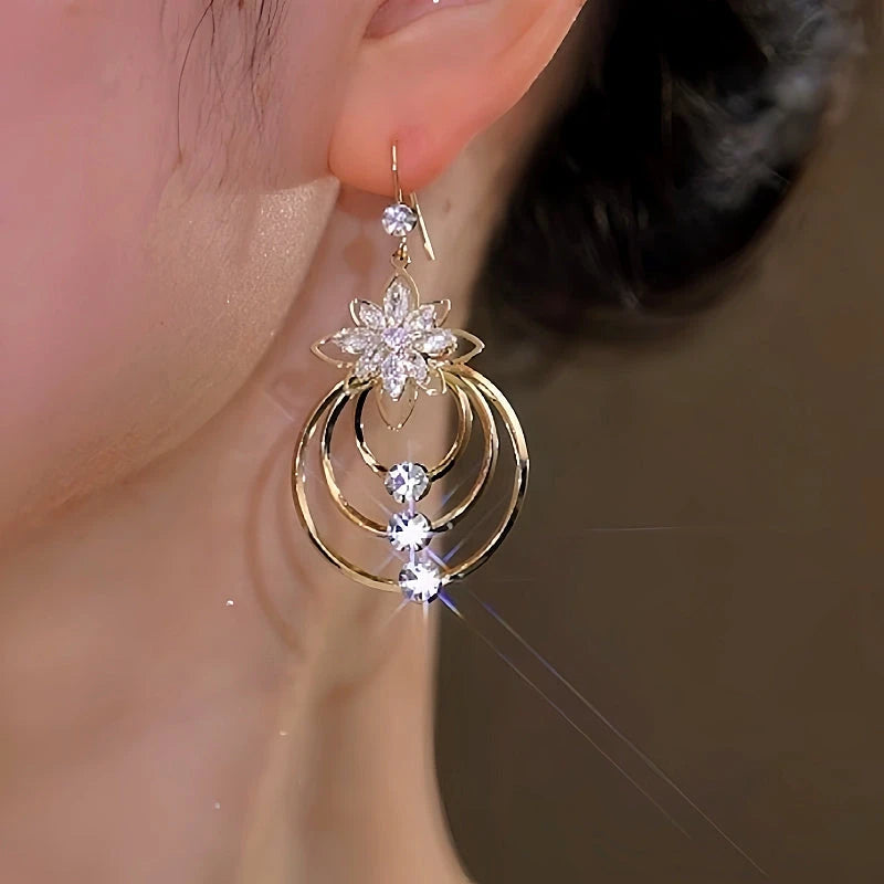 Model showcasing the dangle and style of the 14K Gold-Plated Zircon Ice Flower Ear Hook Earrings
