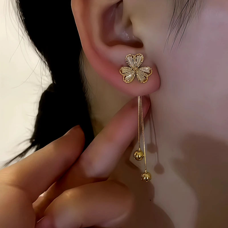 Model showcasing the dangle and style of the 14K Gold-Plated Zircon Inlaid Three-Leaf Flower Hanging Earrings