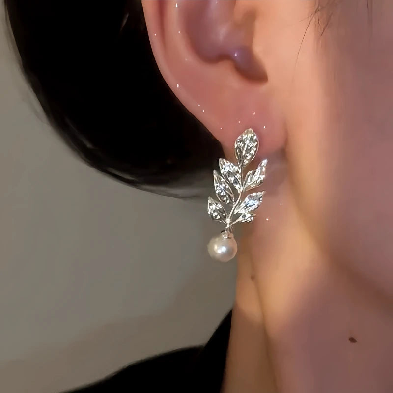 Model showcasing the dangle and style of the 14K Gold-Plated Zircon Leaf Bead Earrings