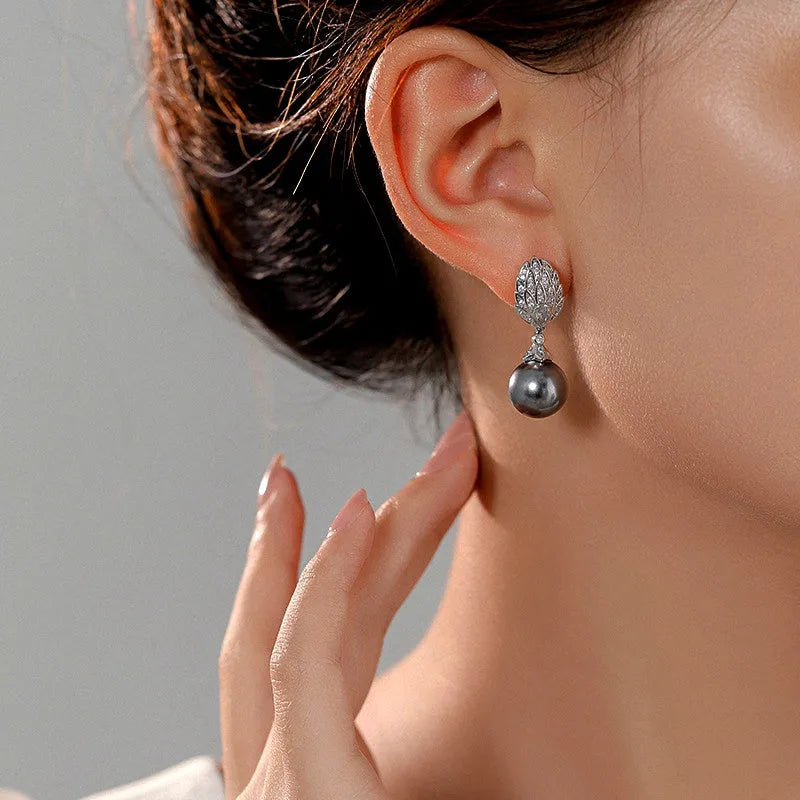 Model showcasing the dangle and style of the 14K Gold-Plated Zircon Leaf Gray Pearl Earrings
