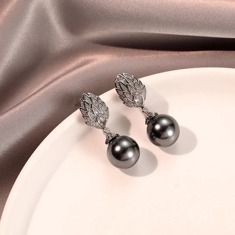 Angled view of the 14K Gold-Plated Zircon Leaf Gray Pearl Earrings