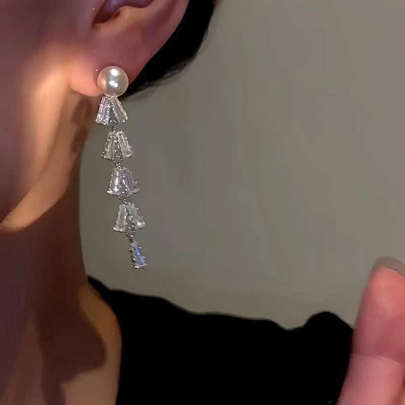 Model showcasing the dangle and style of the 14K Gold-Plated Zircon Leaf Pearl Earrings