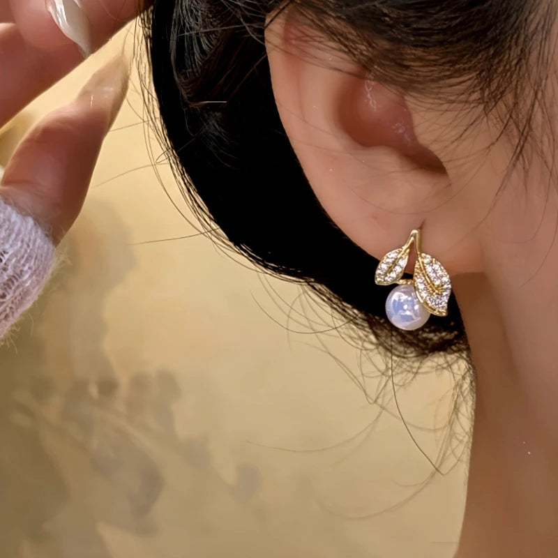 Model showcasing the dangle and style of the 14K Gold-Plated Zircon Leaf Pearl Earrings