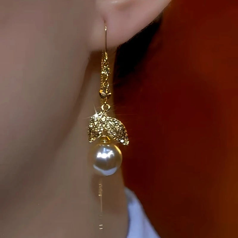 Model showcasing the dangle and style of the 14K Gold-Plated Zircon Leaf Pearl Threader Earrings