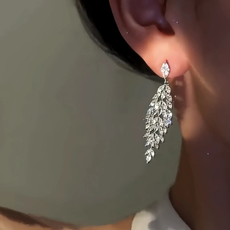 Model showcasing the dangle and style of the 14K Gold-Plated Zircon Leaf Tassel Earrings