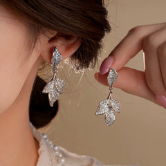 Model showcasing the dangle and style of the 14K Gold-Plated Zircon Leaf Tassel Earrings