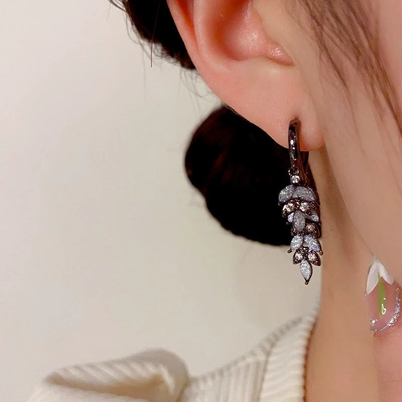 Model showcasing the dangle and style of the 14K Gold-Plated Zircon Leaf Tassel Earrings