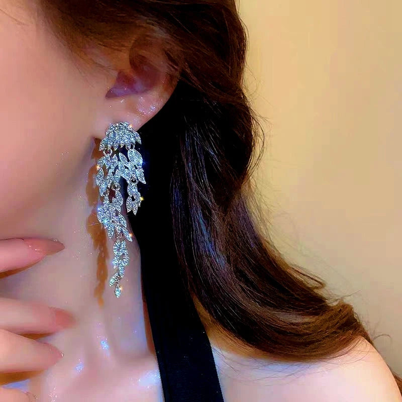 Model showcasing the dangle and style of the 14K Gold-Plated Zircon Leaf Tassel Earrings
