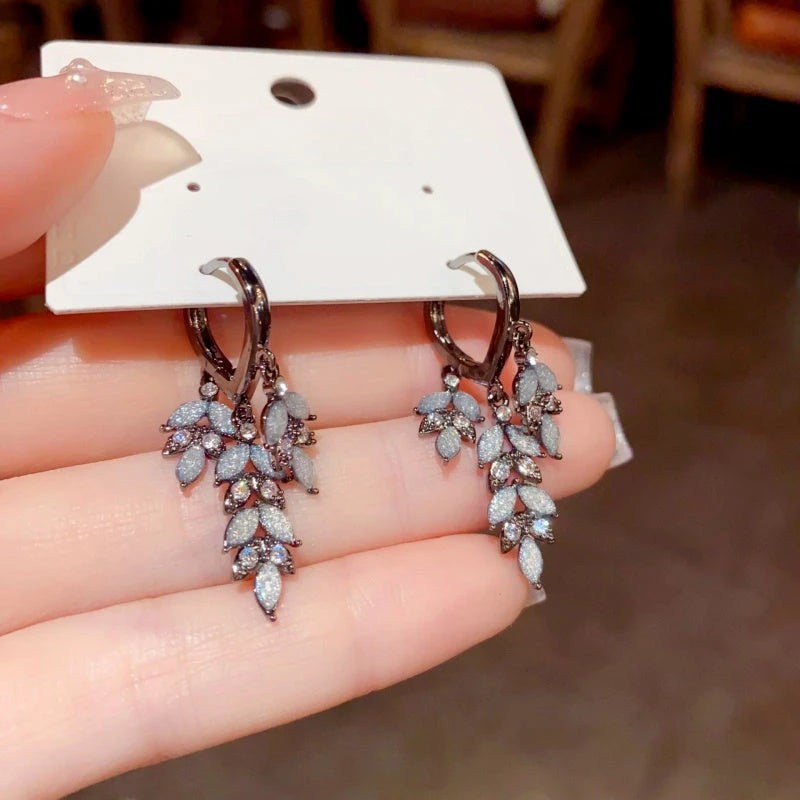 Angled view of the 14K Gold-Plated Zircon Leaf Tassel Earrings