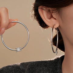 Model showcasing the dangle and style of the 14K Gold-Plated Letter C-Shaped Hoop Earrings