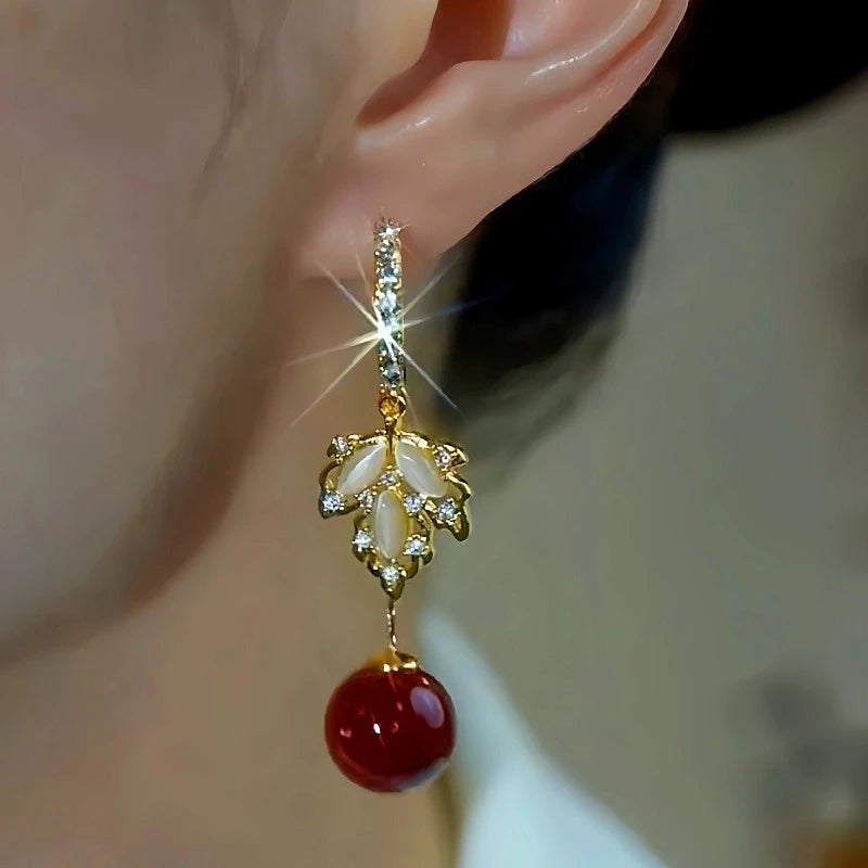 Model showcasing the dangle and style of the 14K Gold-Plated Zircon Maple Leaf Pearl Earrings