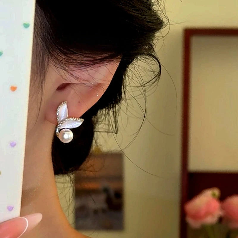 Model showcasing the dangle and style of the 14K Gold-Plated Zircon Mermaid Tail Pearl Earrings
