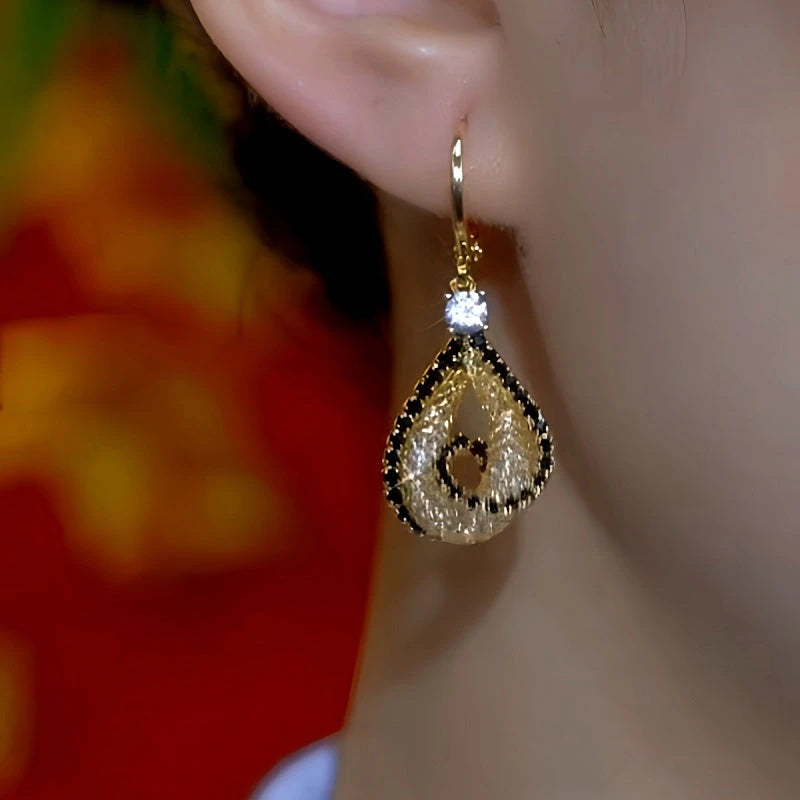 Close-up detail of the sparkling zircons and plating on the gold drop earrings