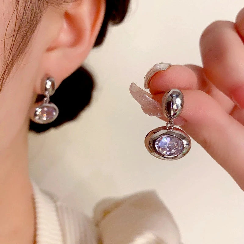 Model showcasing the dangle and style of the 14K Gold-Plated Zircon Oval Earrings