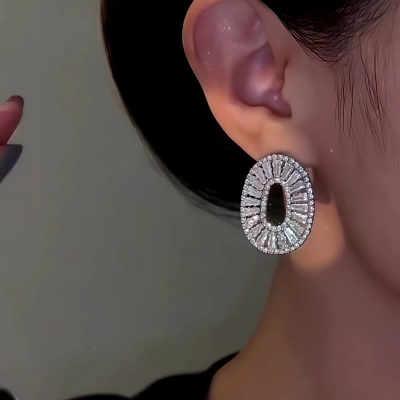 Model showcasing the dangle and style of the 14K Gold-Plated Zircon Oval Earrings